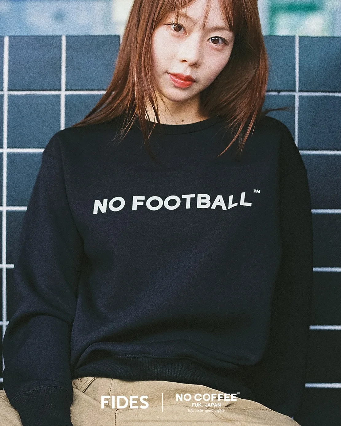 ブラックのNO FOOTBALLスウェットを着用したモデル。